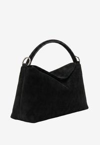 Sac à main en daim noir avec une poignée arquée unique, des anneaux métalliques argentés attachant la poignée au sac, et une fermeture à rabat triangulaire.