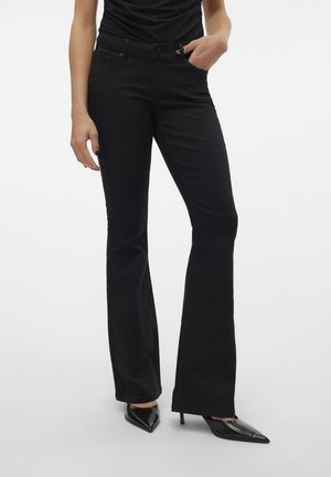 Black flared jeans with a smooth texture, mid-rise waist, five-pocket design, and contrast stitching, paired with pointed black heels.