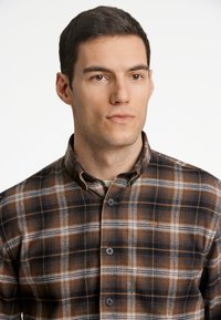 Braun- und schwarz-karierter Flanellhemd mit weißen Akzenten, button-down Kragen und einem kleinen Logo auf der Brust. Standardpassform mit strukturiertem Stoff.