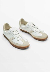 Valkoiset nahkakengät, joissa on beige mokkanahka korostuksia, pyöreä kärki, litteä ruskea kumipohja ja nauhoitus edessä. Miellyttävän sileä pinta.