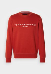 Czerwona bawełniana bluza z okrągłym dekoltem, ściągaczami przy rękawach i wyszywanym logo "TOMMY HILFIGER EST. 1985" na klatce piersiowej.