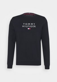 Granatowy sweatshirt wykonany z mieszanki bawełny, z białym haftowanym napisem "TOMMY HILFIGER" i graficznym logo na piersi. Okrągły dekolt, długie rękawy.