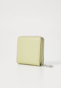 Portefeuille zippé carré en cuir vert clair, doté d'une fermeture éclair argentée et d'une attache pour porte-clés. Texture lisse avec des détails de couture soignés.