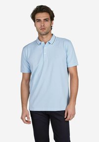 Lichtblauw poloshirt met een kraag, twee knopen en contrasterende afwerking langs de kraag. Eenvoudig ontwerp met korte mouwen.