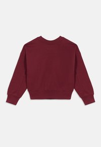 Sweatshirt granada com decote redondo, mangas longas e punhos canelados. Textura suave com uma cintura ligeiramente ajustada nas costas.