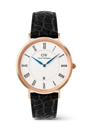 Montre classique Daniel Wellington avec boîtier en or rose, cadran blanc, aiguilles bleues, chiffres romains noirs, fenêtre de date et bracelet en cuir noir texturé.