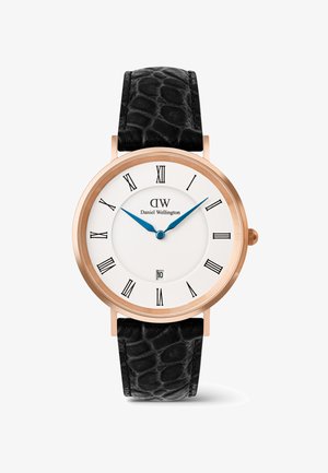 Klassinen Daniel Wellington -rannekello ruusukultaisella kotelolla, valkoisella viisariolevalla, sinisillä osoittimilla, mustilla roomalaisilla numeroilla, päivämääräikkunalla ja mustalla teksturoidulla nahkarannekkeella.