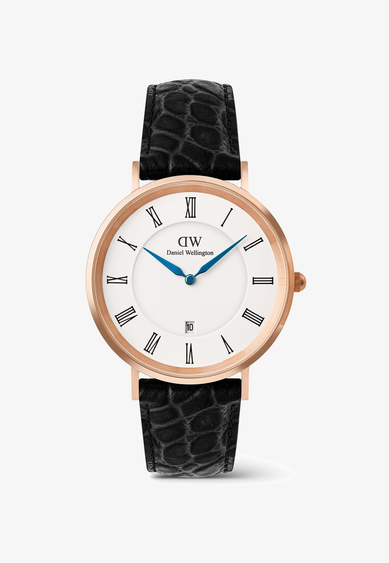 Montre classique Daniel Wellington avec boîtier en or rose, cadran blanc, aiguilles bleues, chiffres romains noirs, fenêtre de date et bracelet en cuir noir texturé.