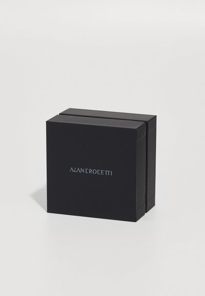 Must värviline kast sileda tekstuuriga, esiäärsel on logo "ALAN CROCEETTI" metalliksinises. Kompaktne disain puhaste servadega.
