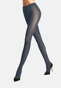 Przezroczyste granatowe rajstopy o błyszczącym wykończeniu, z gładką fakturą i wysokim stanem, w połączeniu z czarnymi szpilkami.
