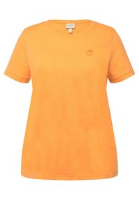 Camiseta de algodón naranja con mangas cortas, cuello redondo y un pequeño logo de manzana en tono sobre tono en el área del pecho izquierdo. Textura suave.