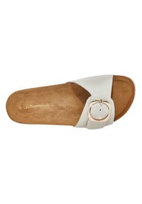 Sandal de piel blanca con suela texturizada beige, que presenta un detalle de hebilla redonda en tono dorado en la tira.