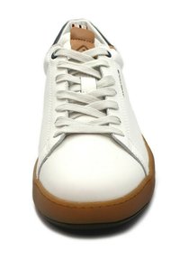 Zapatilla de cuero blanca con puntera redondeada, cordones de algodón planos, suela de goma marrón y un acento de cuero marrón en la lengüeta. Costuras grises sutiles.