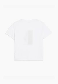 Hvid t-shirt med kortærmer, løst fit og et subtilt, falmet grafisk design på ryggen. Blødt bomuldsstof.
