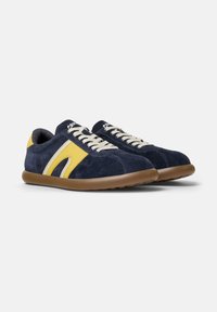 Sneakers in suede blu scuro con accenti gialli e bianchi, lacci beige e suola marrone. Forma arrotondata con dettagli di design imbottiti.