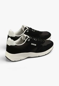 Sneaker nere realizzate con materiali in suede e mesh, dotate di una suola intermedia bianca, lacci neri e un'etichetta con logo sul lato.