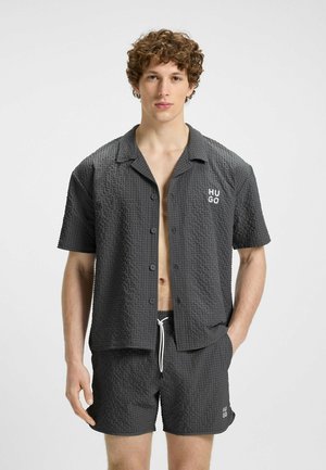 Gray button-up shirt with a textured pattern, short sleeves, and "HUGO" logo. Paired with matching shorts featuring a drawstring waist.