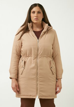 Lys beige pufferjakke med lynlås foran, opretstående krave, indsnævret talje og to lynlåslommer i siderne. Glat tekstur og korte ærmer.