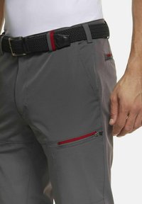 Graue Cargo-Hosen mit strukturierter Oberfläche, ausgestattet mit einem geflochtenen schwarzen Gürtel und roten Reißverschlussakzenten an den Taschen. Glattes, figurbetontes Design.