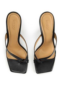 Sandales en cuir noir sans lacets avec des bouts carrés et des fines lanières sur des semelles intérieures couleur tan, disposées côte à côte sur un fond blanc.