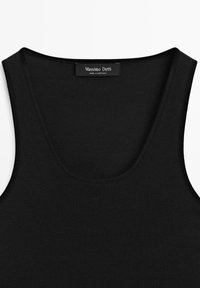 Débardeur noir côtelé sans manches avec encolure arrondie, étiquette « Massimo Dutti, Made in Portugal » à l’intérieur du col.