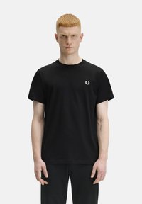 T-shirt in cotone nero con scollo rotondo e maniche corte. Presenta un piccolo logo ricamato bianco nella zona sinistra del petto.