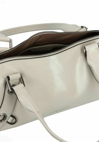 Borsa a tracolla in pelle color crema con una texture liscia, hardware in argento, chiusura con zip e interno foderato in tessuto marrone.