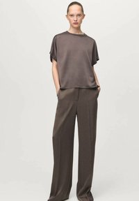 Brown, short-sleeved top in a smooth fabric, paired with wide-leg brown trousers. Both garments feature a relaxed fit and minimal detailing.