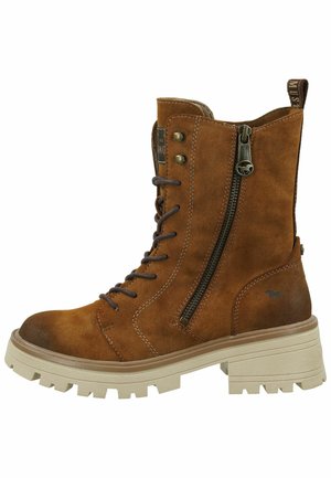 Bottine en suède marron avec lacets et fermeture éclair, semelle en caoutchouc beige épaisse et coutures marron. Présente un détail de logo sur le côté.