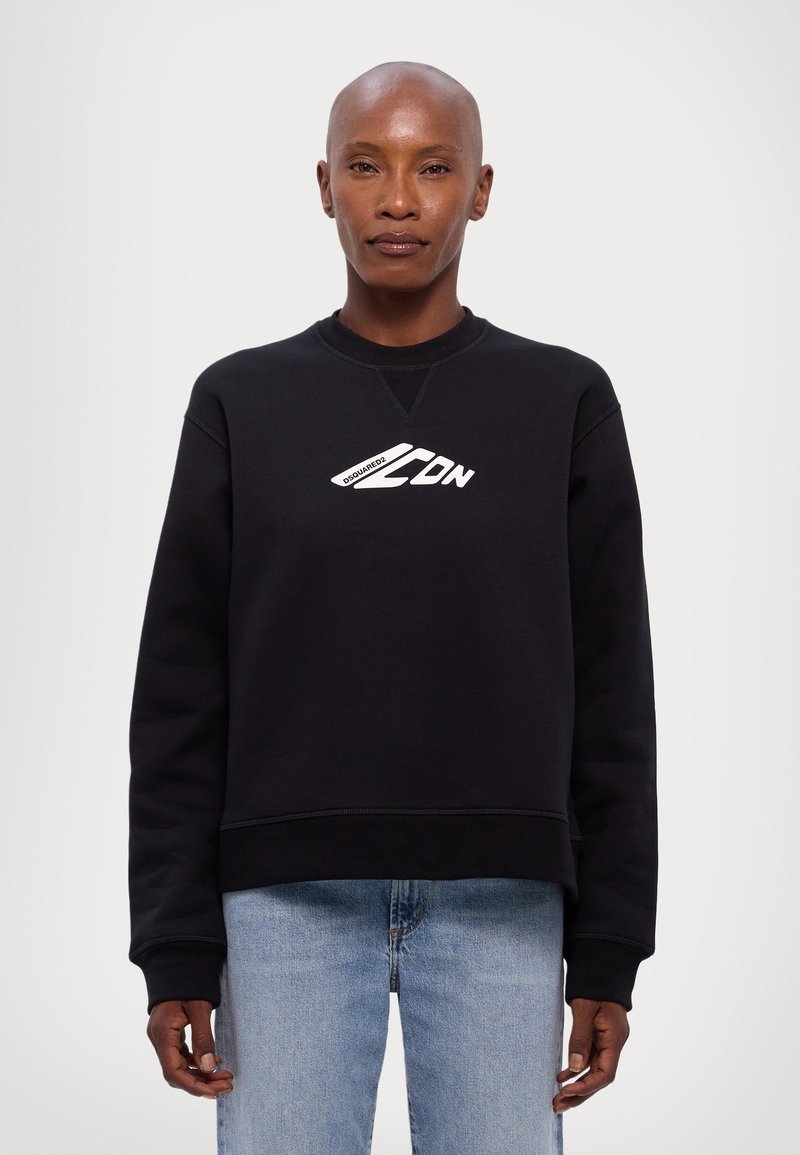 Black sweatshirt with a round neck, ribbed cuffs, and hem, featuring white graphic text on the front. Worn with light blue jeans.
