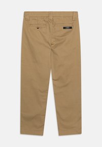 Beige chino nadrág egyenes szabással, övhurkokkal, két hátsó zsebbels és a deréknál varrott címkével. Sima textúrájú anyag.