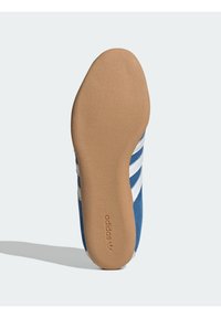 Scarpa sportiva in pelle scamosciata blu con strisce bianche, dotata di suola in gomma e logo inciso sul fondo per trazione e durata.