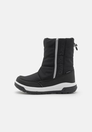 Botte d’hiver noire mi-mollet avec semelle blanche, cordon de serrage en haut et texte "Calvin Klein Jeans" sur le panneau latéral.