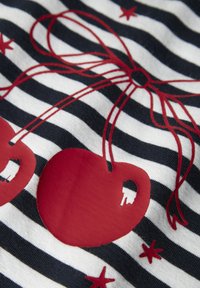 Tela de algodón con rayas azul marino y blancas, con motivo de cerezas rojas y una cinta, acentuada con pequeñas estrellas rojas. Textura suave.