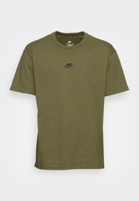 Olivgrön bomulls t-shirt med korta ärmar, rund halsringning och en liten svart Nike-logotyp på bröstet. Enkelt, strömlinjeformat design.