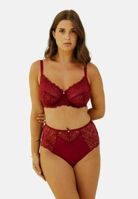 Soutien-gorge en dentelle bordeaux avec armatures et bords festonnés, associé à une culotte taille haute ornée d'accents en dentelle et d'un bouton décoratif.