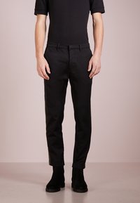 Black tailored pants made from a smooth fabric with a slim fit, featuring front pockets and a clean waistband detail.