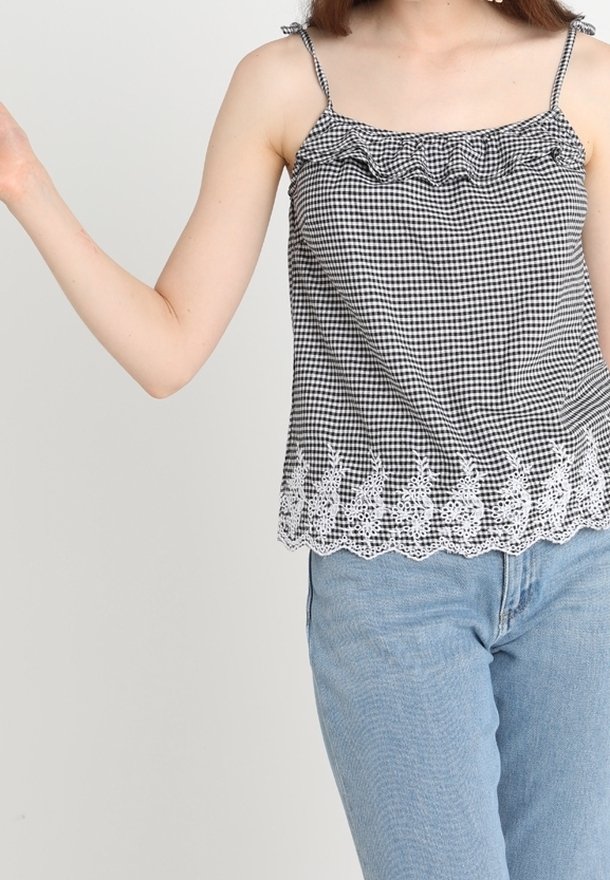 Black and white gingham sleeveless top with ruffled neckline and white lace trim featuring a scalloped edge and bunny pattern at the hem.