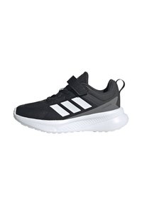Chaussure de sport noire avec des accents gris, présentant une tige en maille, une sangle Velcro et trois rayures blanches. Semelle intercalaire blanche épaisse pour l'amorti.