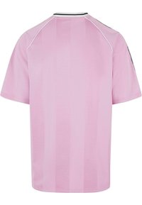 Pink sports jersey featuring short sleeves, a round neckline, and vertical stripe pattern. Contrasting black and white accents on collar.