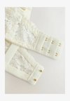 Merevítős melltartó - cream