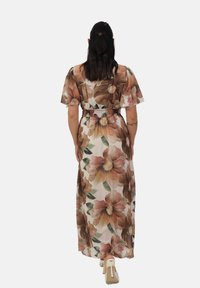 Robe maxi avec un motif floral dans des tons chauds, dotée de manches courtes, d'une taille froncée et d'un tissu léger et transparent.