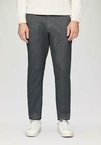 Grijze gemêleerde broek met een tailored fit, rechte pijpen en steekzakken, gecombineerd met witte sneakers.