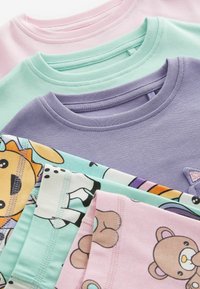 Fyra t-shirts med kort ärm i pastellfärger: rosa, mintgrön och lavendel, med tryck av tecknade djur och kontrasterande ribbade halslinningar.