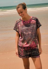 Patroonoutfit met lichte, levendige stof in roze, paars en blauwe tinten, met een relaxed fit, golvende randen en een casual ontwerp.