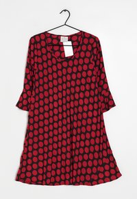 Kleid mit rot-schwarzem Pünktchenmuster, weitem Ausschnitt, Dreiviertelärmeln und einem ausgestellten Saum. Aus weichem, leichtem Stoff gefertigt.