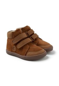 Zapatos altos de ante marrón con dos correas de Velcro, punta redondeada y suela de goma. Presenta un logo en el lateral y un forro interior suave.