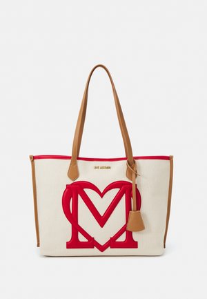 Sac fourre-tout crème avec poignées et bordures couleur fauve, arborant un grand motif en forme de cœur rouge avec un M à l'avant.
