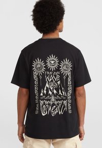 Sort bomulds T-shirt med ryggrafik, der viser abstrakte solmotiver, teksten "FROZEN WAVE CULT" og bjergbilleder i hvid blæk.