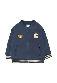Giubbotto blu navy con zip realizzato in morbido tessuto. Presenta una toppa d'oro a forma di orso, una lettera "C" e polsini e orlo a righe. Due tasche con zip.